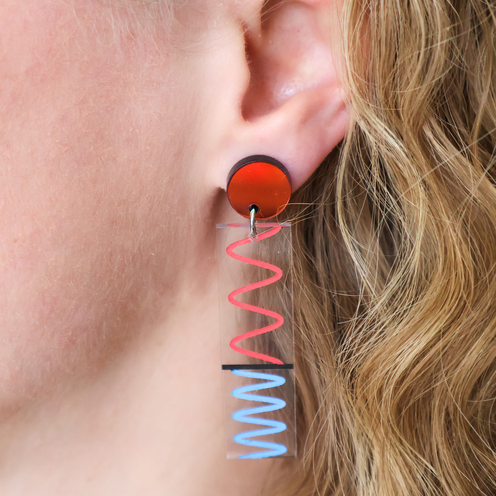 Laser cut acrylic doppler effect dangle earrings, being modelled. 