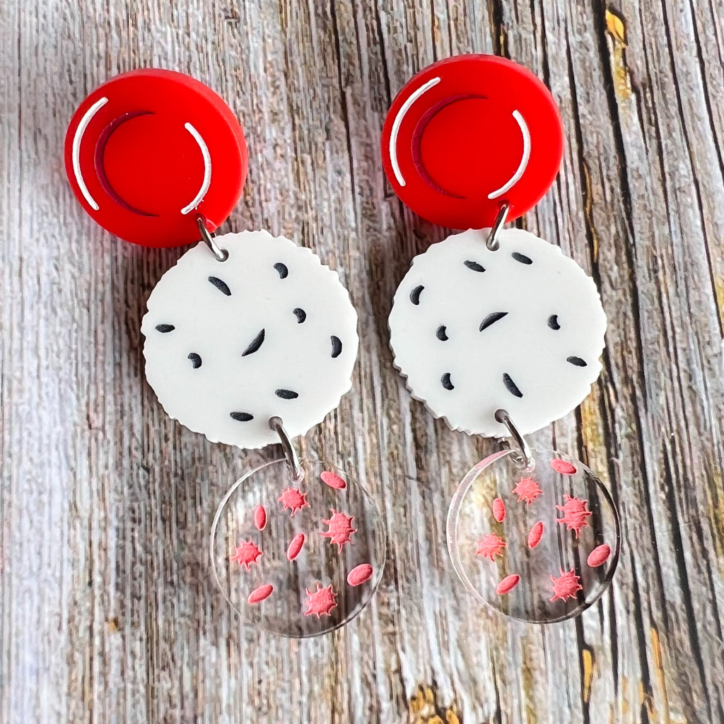 Dangle earrings comprising of a red blood cell topper, with a white blood cell and platelets dangling underneath. Laser cut and handpainted from acrylic. 