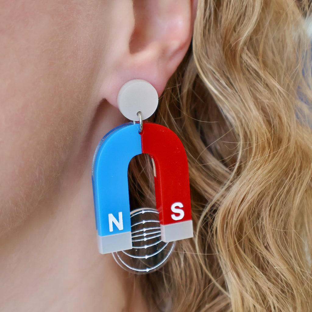 Laser Cut Acrylic HorseShoe Magnet Earrings. Blue, Red and Silver, being modelled.