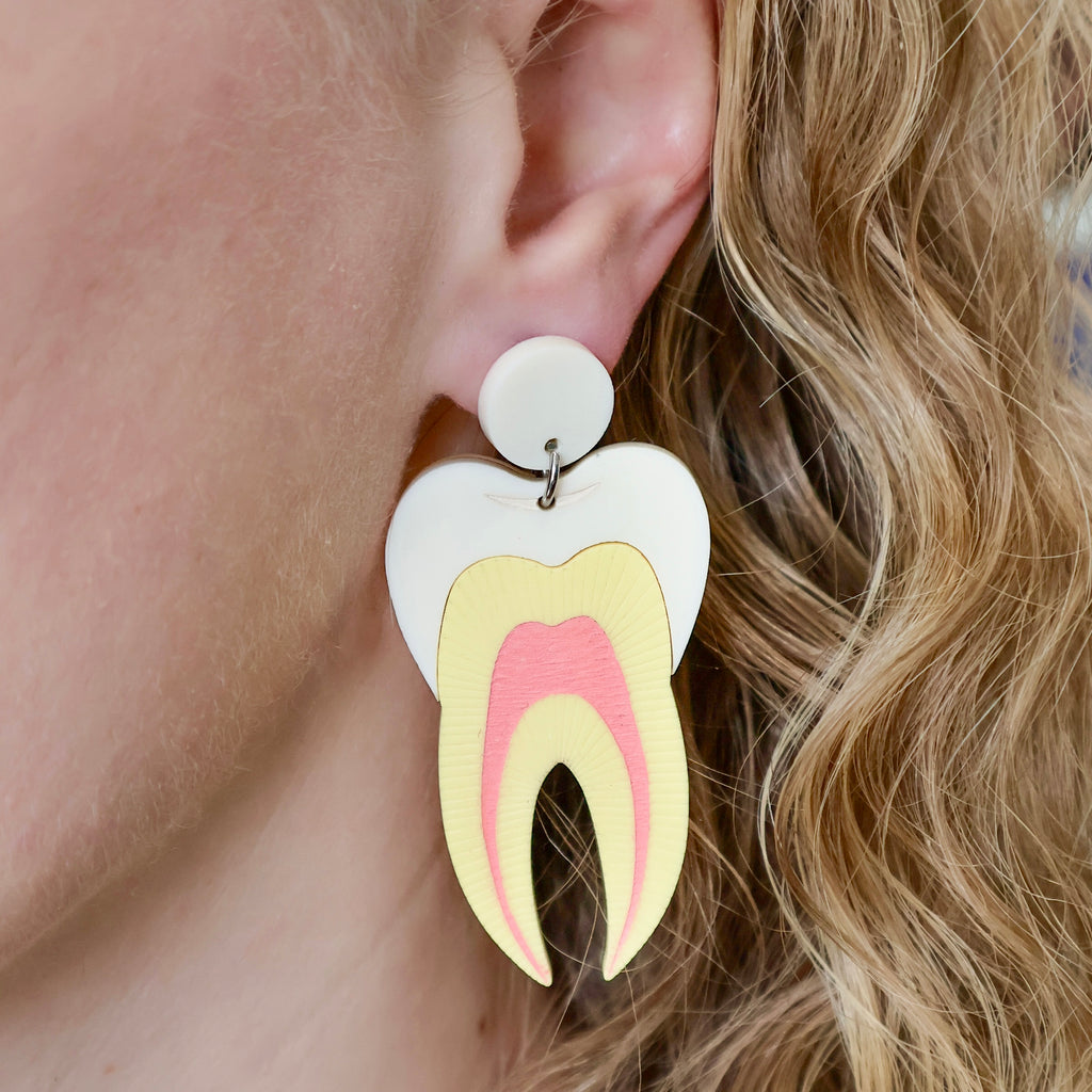 Tooth earrings being modelled, laser cut from acrylic and showing a cross-sectional view. 