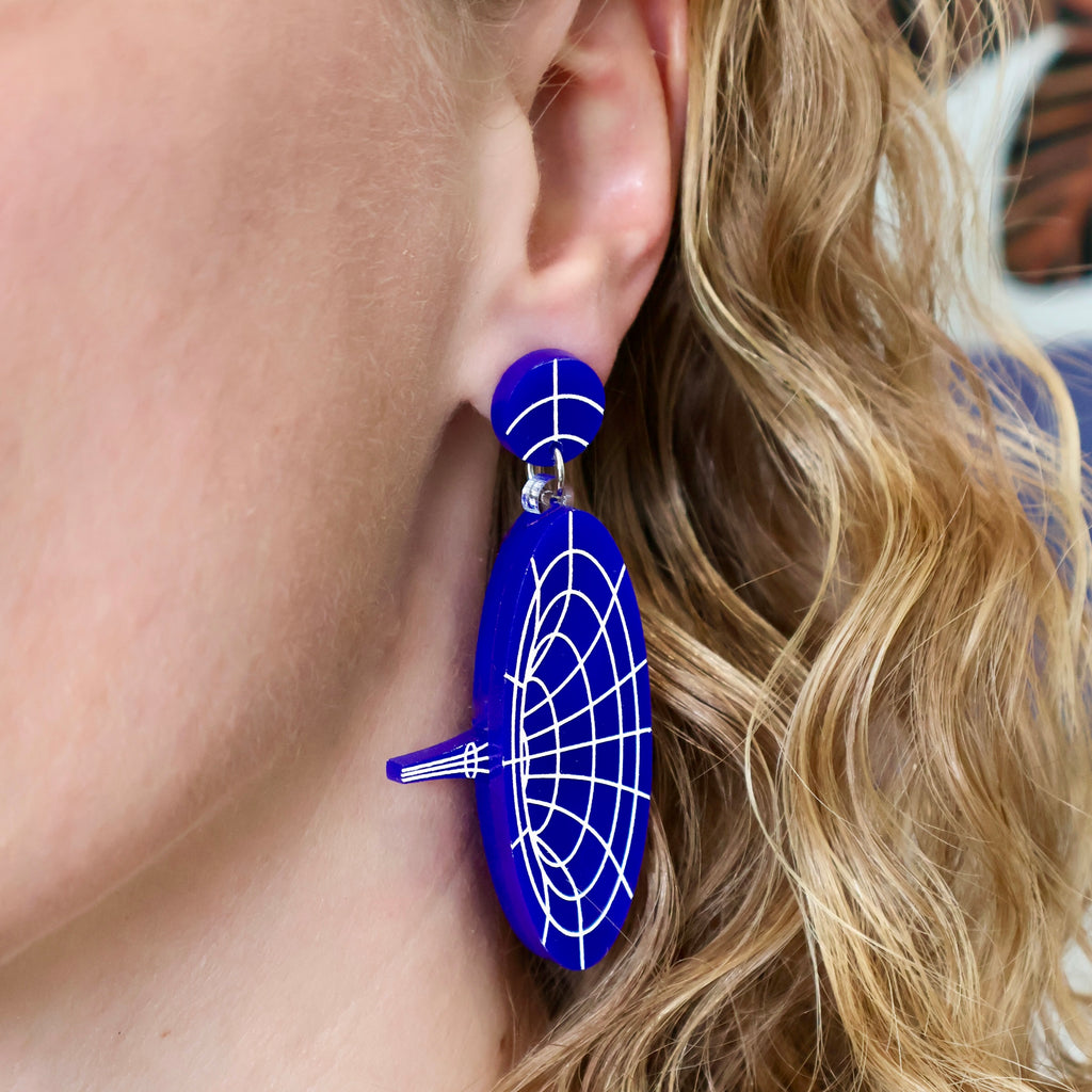 Dark blue dangle acrylic wormhole earrings, being modelled 2.