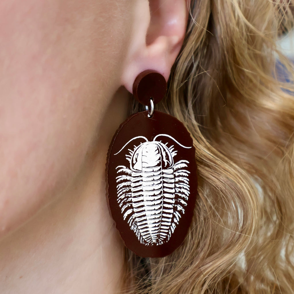 Dark Brown Trilobite Faux Fossil Earrings from Laser Cur Acrylic, being modelled. 