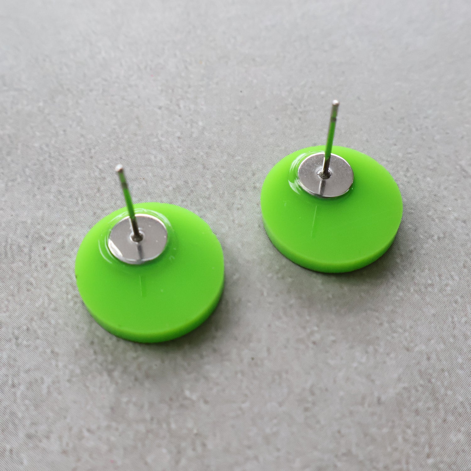 Back view of green biohazard studs showing stainless steel earring posts.
