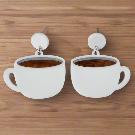 White coffee cup earrings with brown center and white round toppers on a grey background