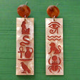 Pair of earrings with Egyptian hieroglyphics on a marble background