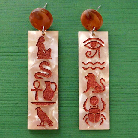 Pair of earrings with Egyptian hieroglyphics on a marble background