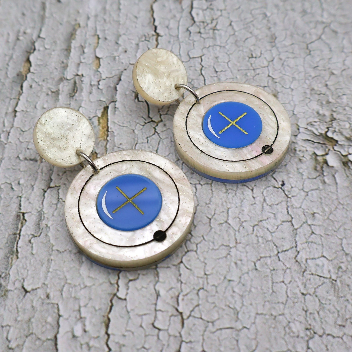 Closeup view of hydrogen atom dangle earrings made from laser cut acrylic.
