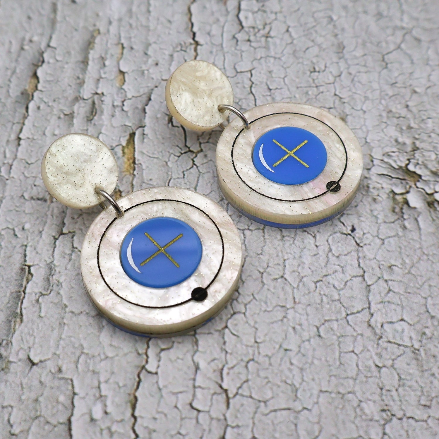 Closeup view of hydrogen atom dangle earrings made from laser cut acrylic.