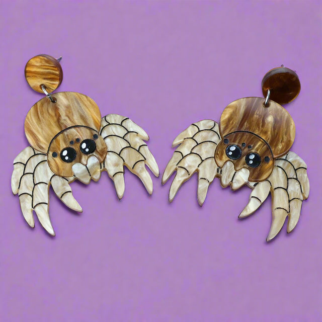 Laser cut acrylic jumping spider dangle earrings, closeup.