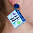 Earring with 'Marine Biology' design on a book-shaped dangle, worn on an ear.