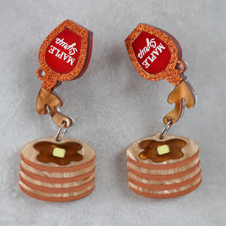 Earrings with pancake and syrup design on a gray background