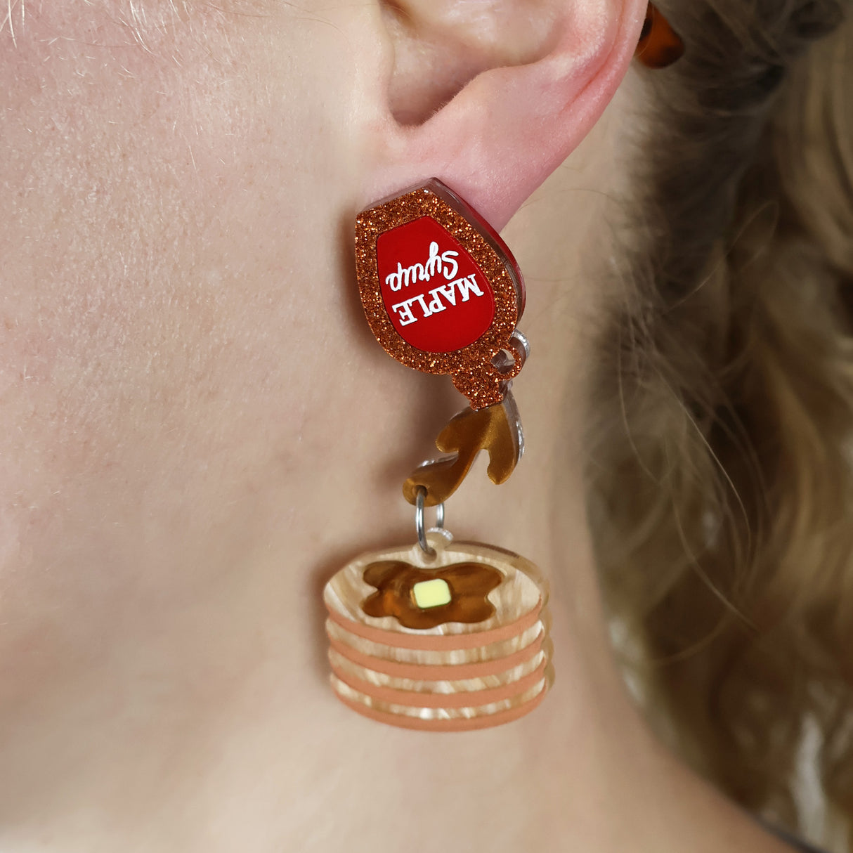 Acrylic pancake dangle earrings with a maple syrup earring topper, being modelled