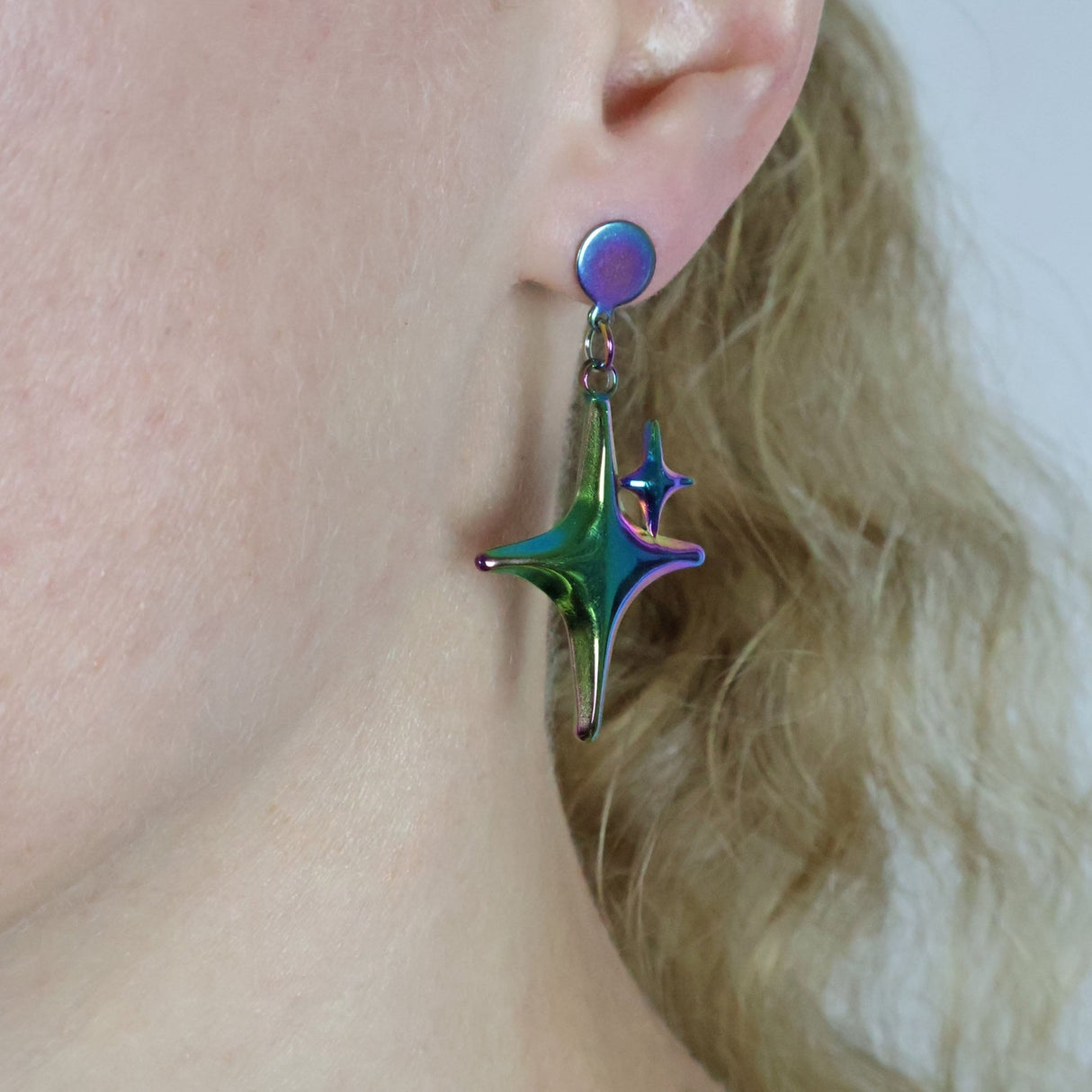 Close-up of a person wearing a colorful earring with a star design.