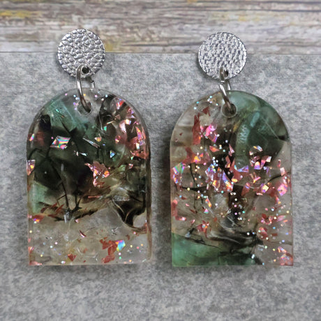 A pair of one of a kind arch shaped recycled acrylic earrings with green and pink design titled 'Enchanted Forest' and stainless steel toppers. Pair 103-06