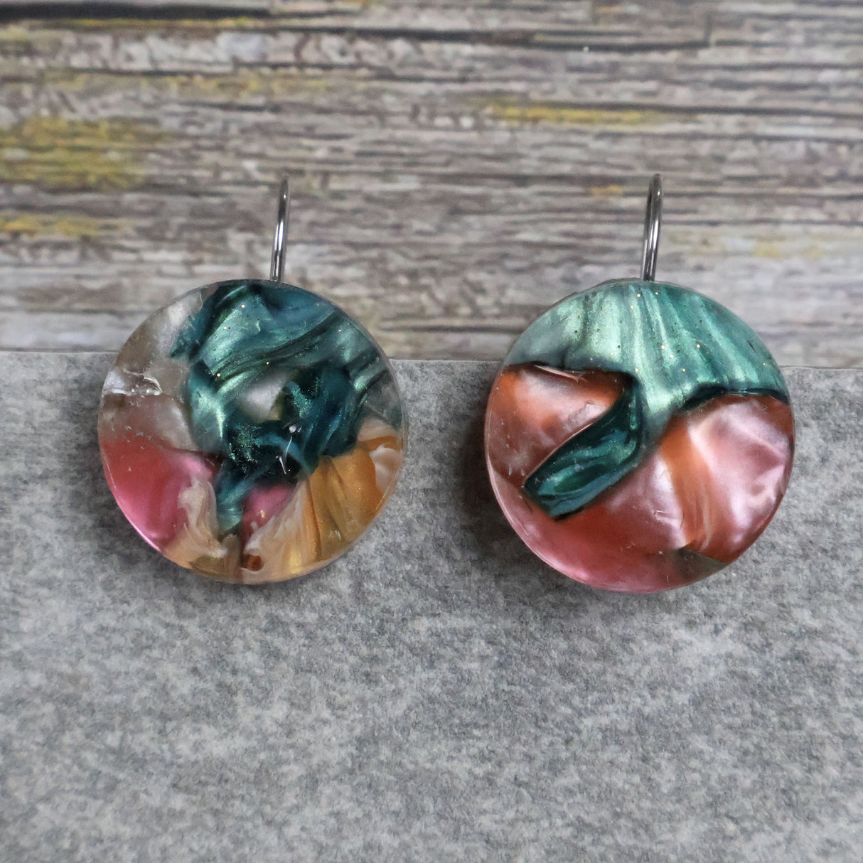 A pair of one of a kind round recycled acrylic earrings with stainless steel french hooks and multicolored design titled 'Sunset Reef'. Pair 106-115