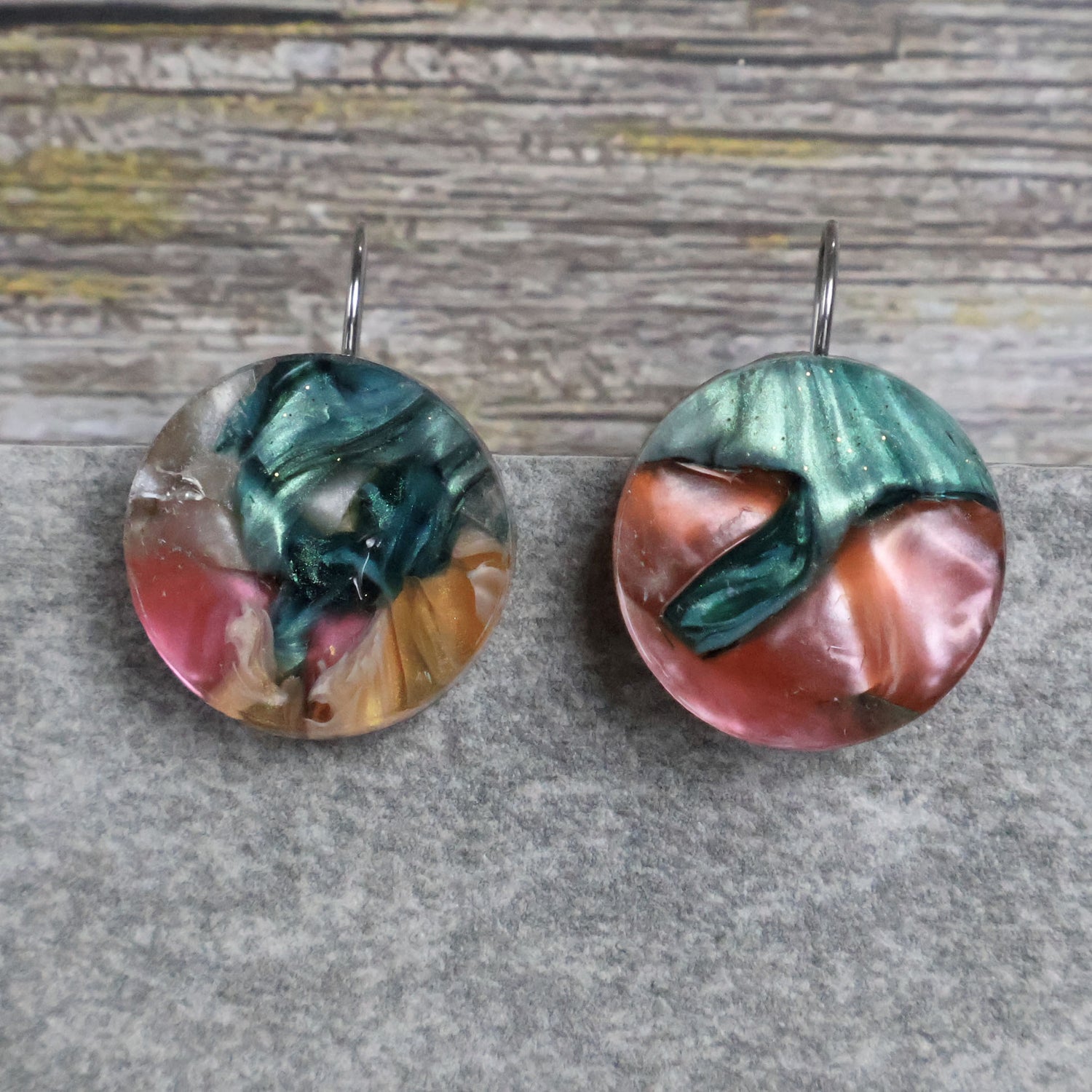 A pair of one of a kind round recycled acrylic earrings with stainless steel french hooks and multicolored design titled 'Sunset Reef'. Pair 106-115