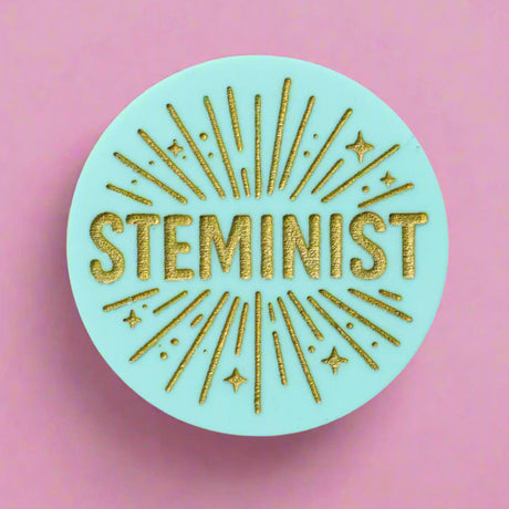 Round teal acrylic brooch with 'STEMINIST' in gold text