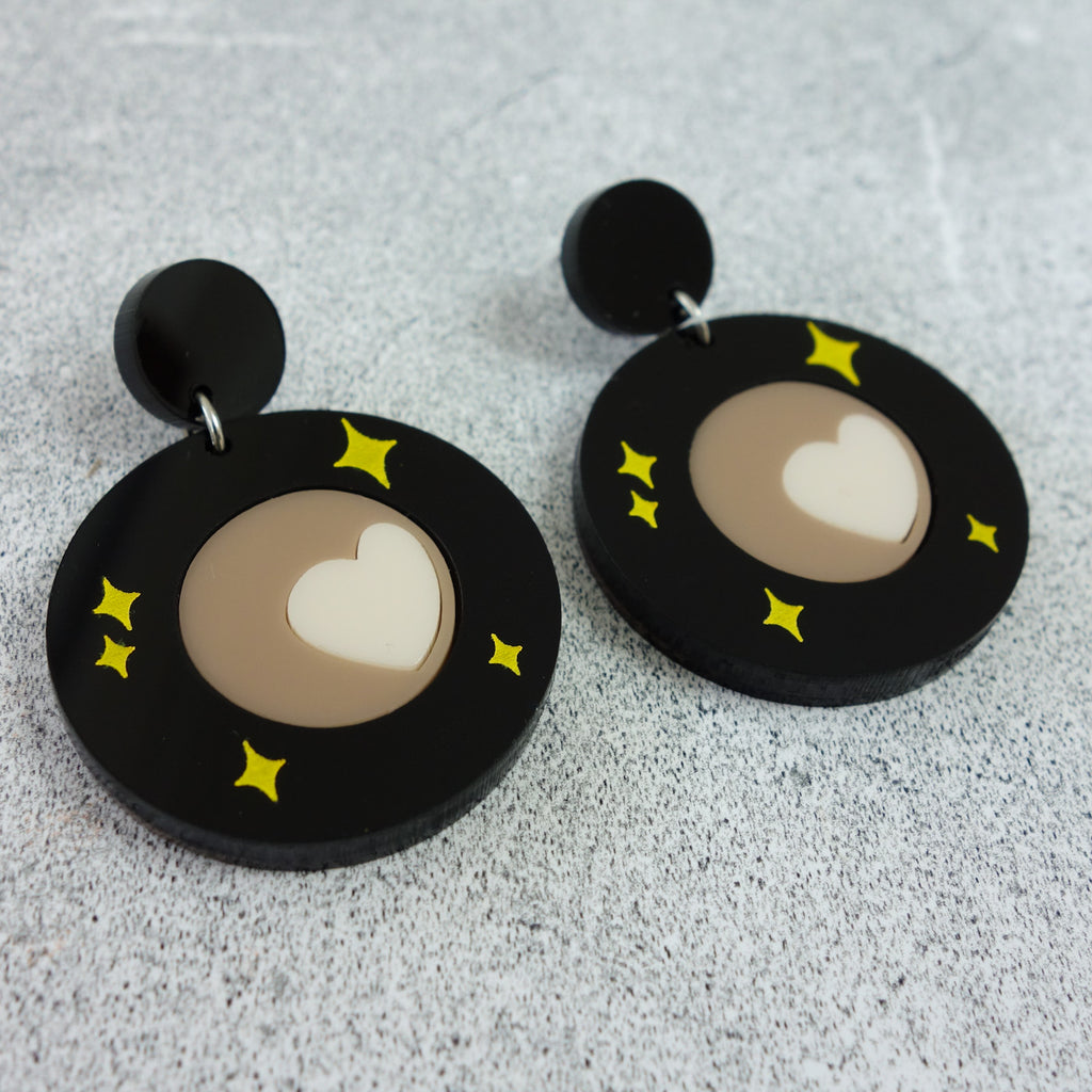 Laser cut acrylic Pluto Earrings showing Tombaugh Regio. Close up view.