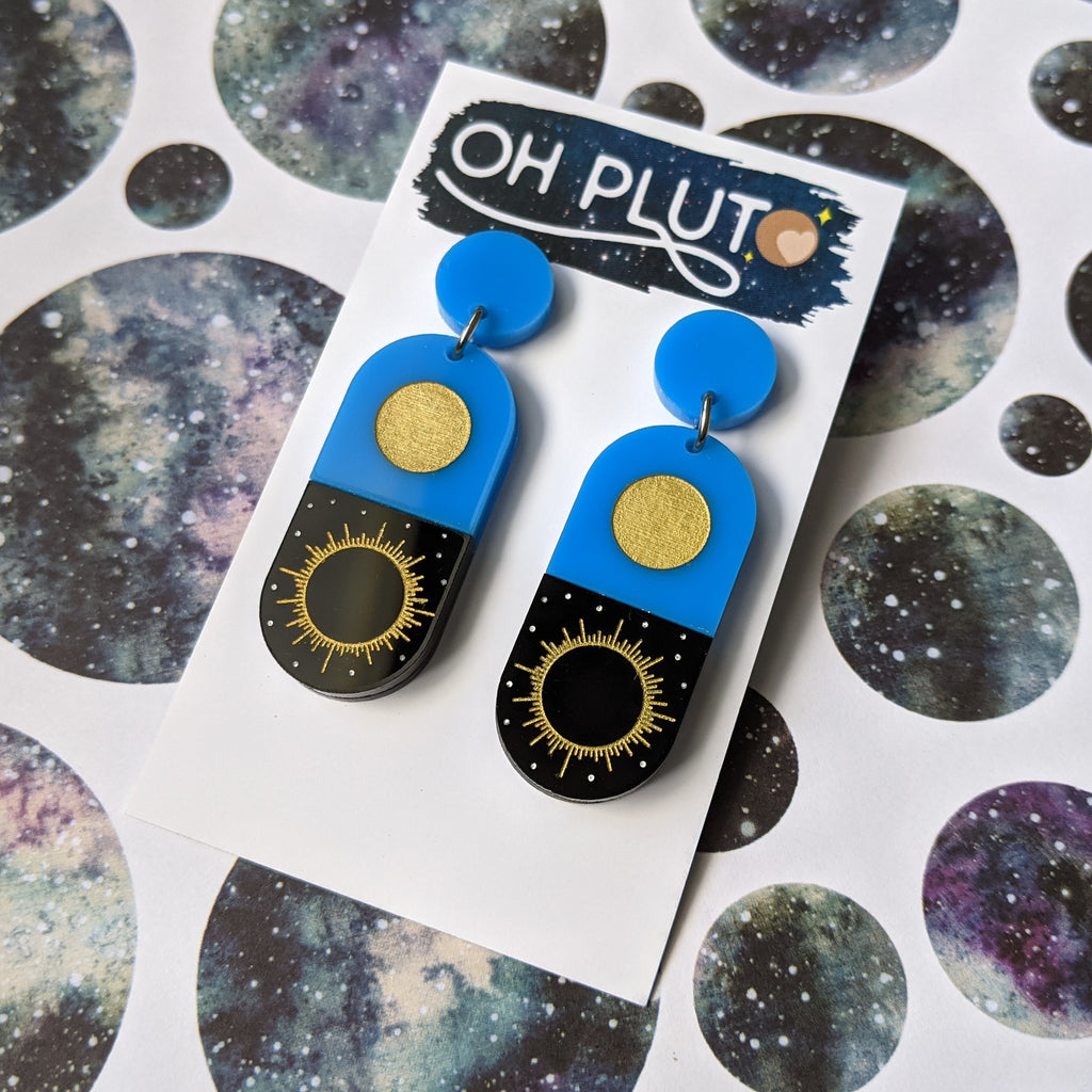 Blue and Black Total Solar Eclipse earrings. Laser cut in acrylic, displayed on earring card.