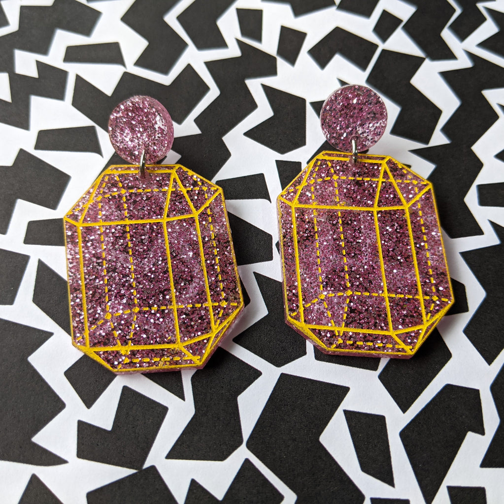 Pink glitter crysalline structure earrings with yellow handpainted outlines of the crystal structure. Design 2.
