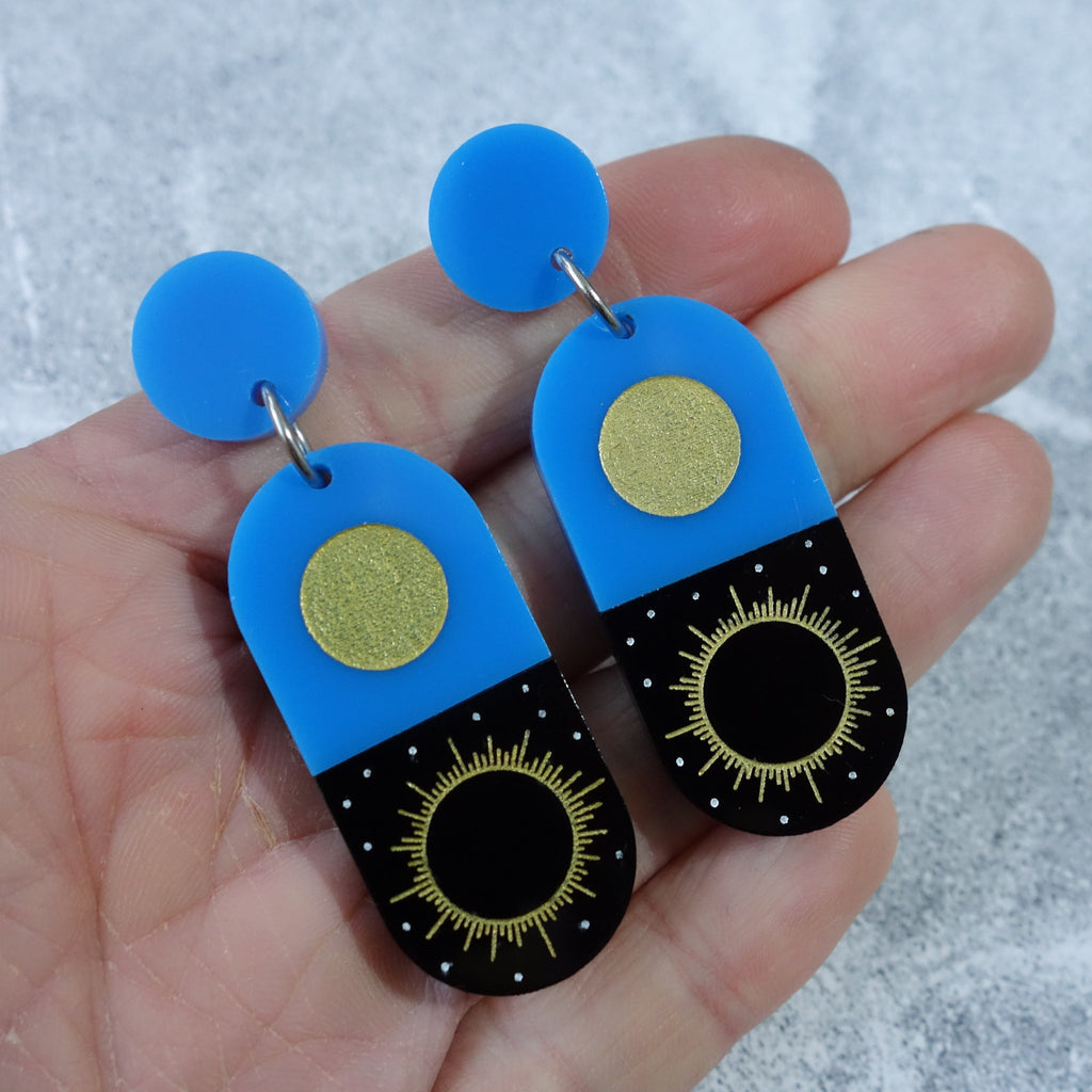 Blue and Black Total Solar Eclipse earrings. Laser cut in acrylic. Close up view.