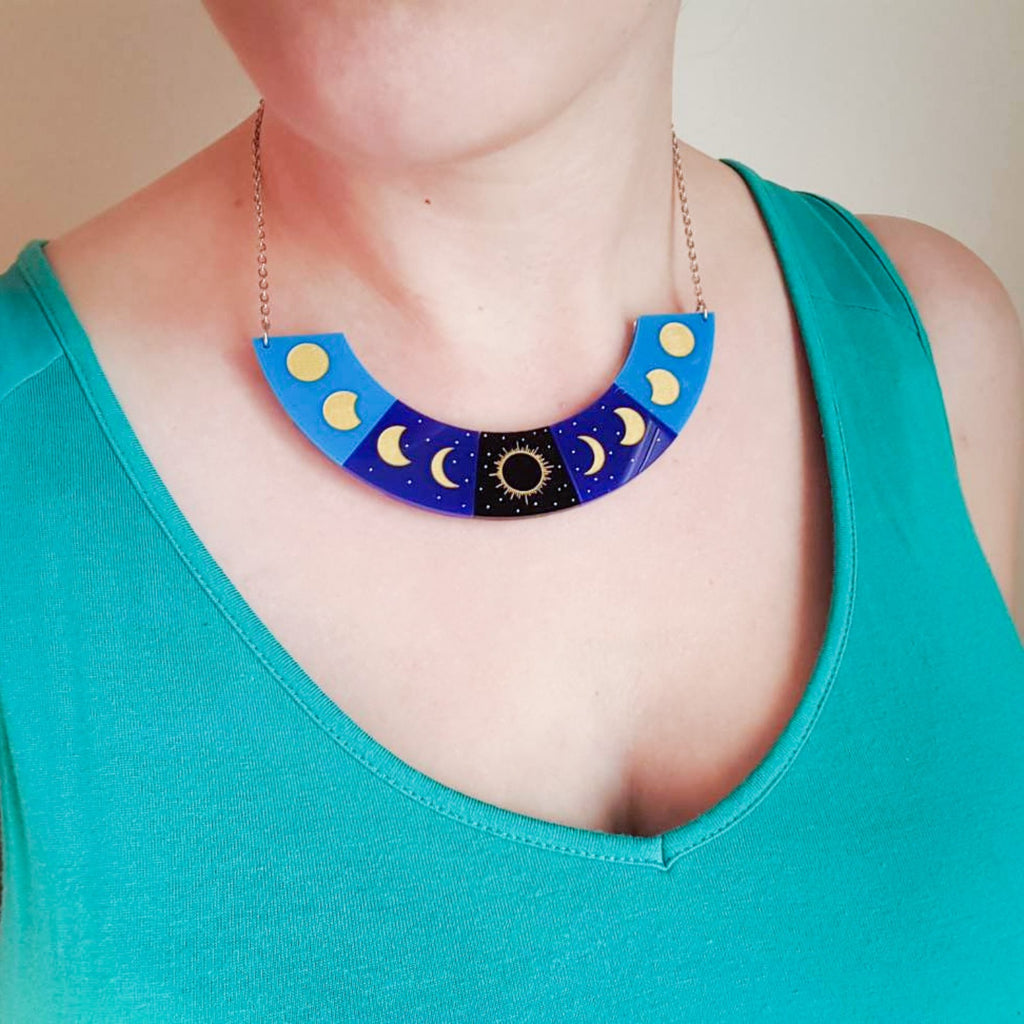 Half circle total solar eclipse necklace in laser cut acrylic, being modelled.