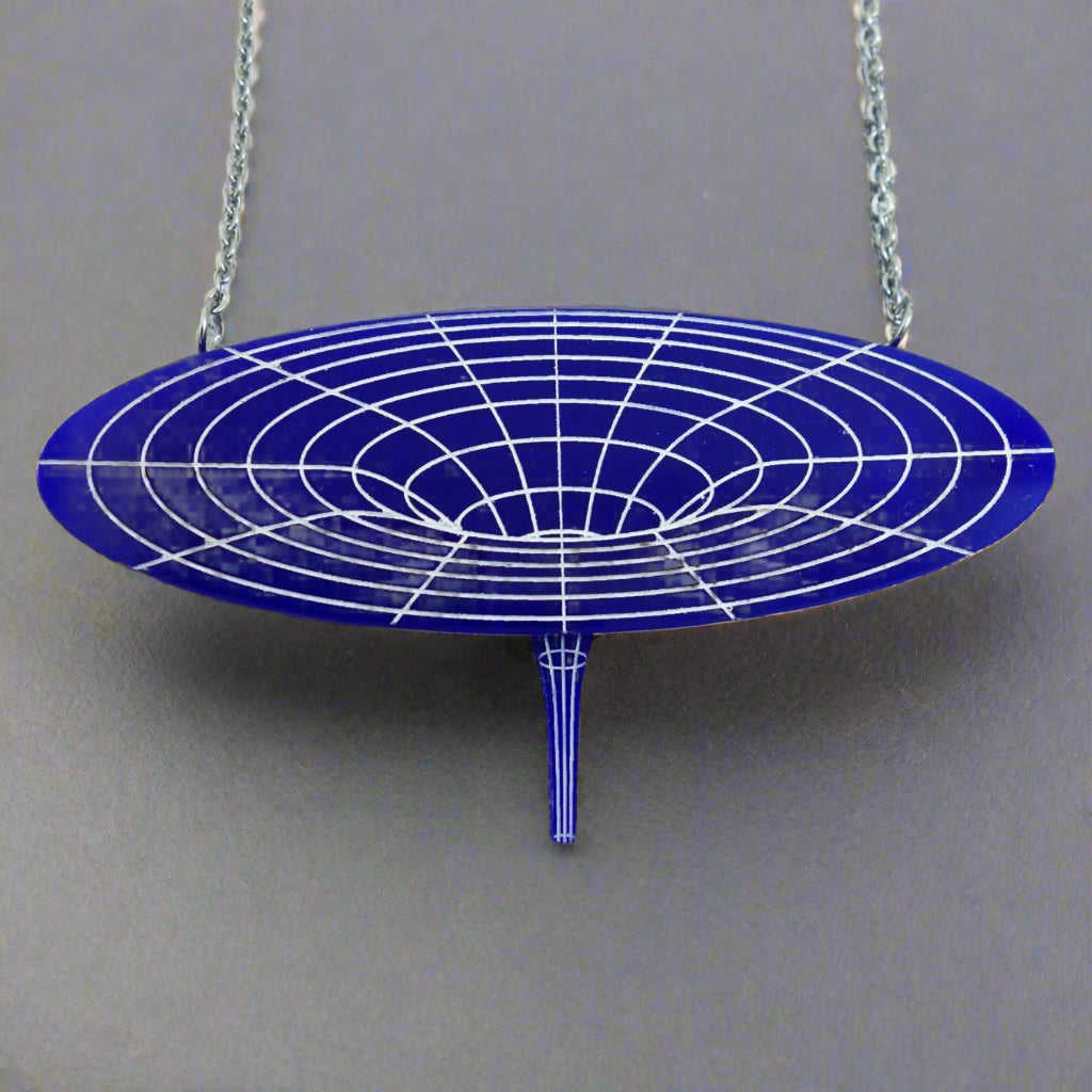 Dark blue black hole acrylic necklace up close. For Astronomy lovers.