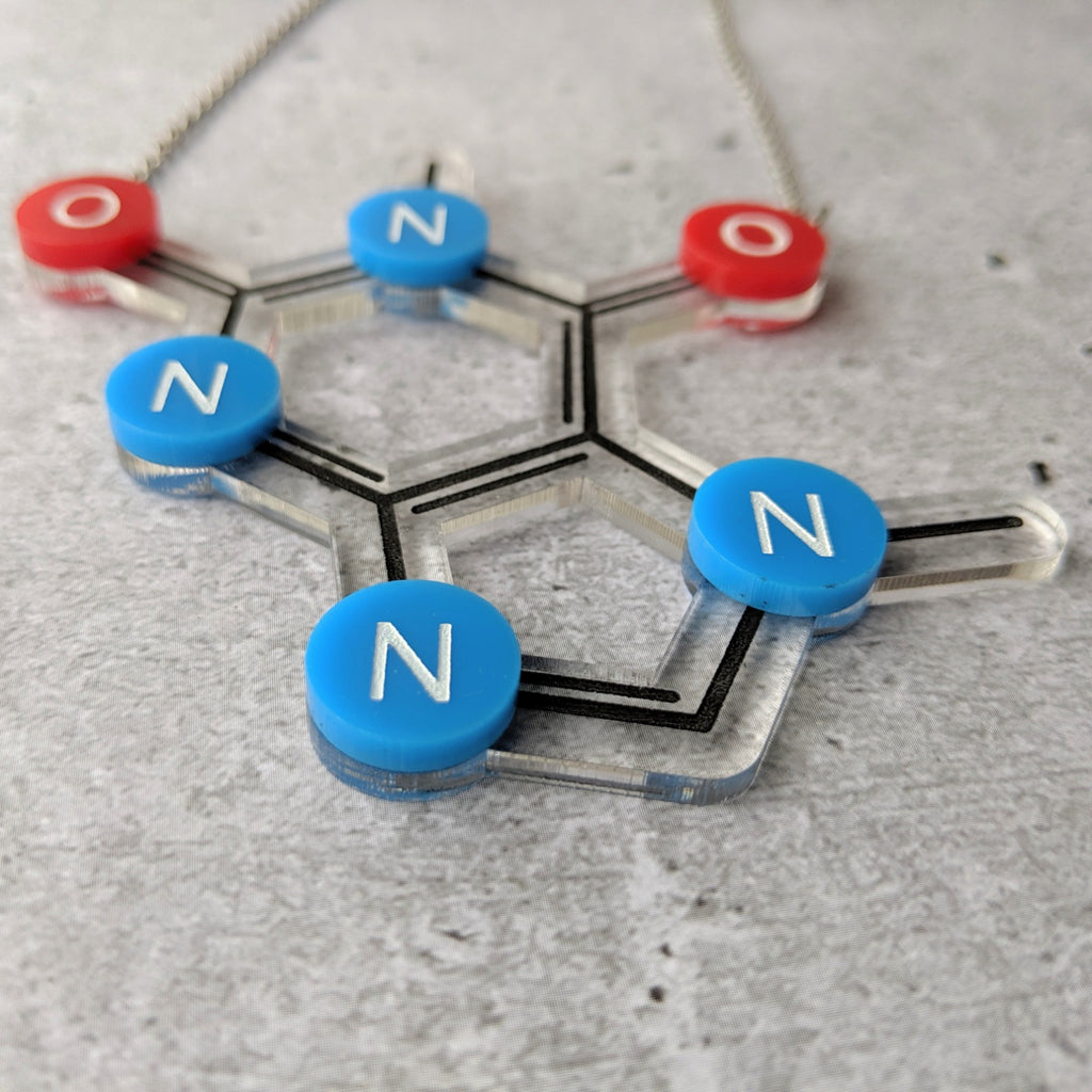 Caffeine Molecule Necklace in Laser Cut Acrylic closeup. With Oxygen red oxygen and blue nitrogen components. Angled view.