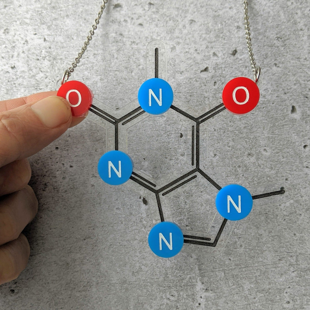 A caffeline molecule necklace made from laser cut acrylic, showing red oxygen and blue nitrogen atoms.