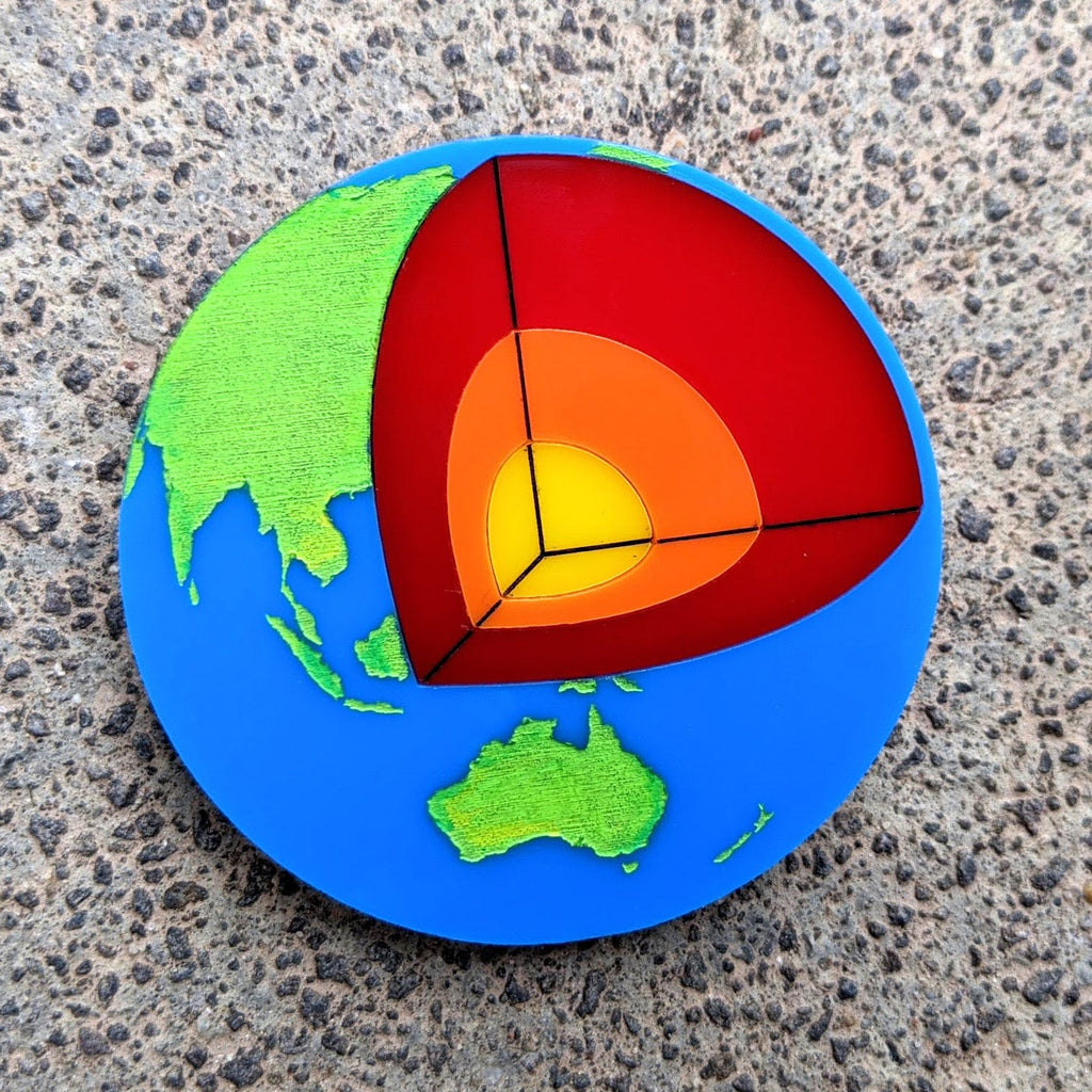 Acrylic Earth brooch showing the cross-sectional layers to the earths core.