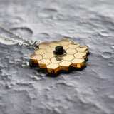 Angled view of JWST pendant against a lunar backdrop