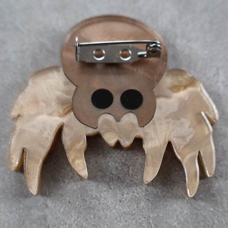 back view of a jumping Spider-shaped brooch showing stainless steel brooch pin
