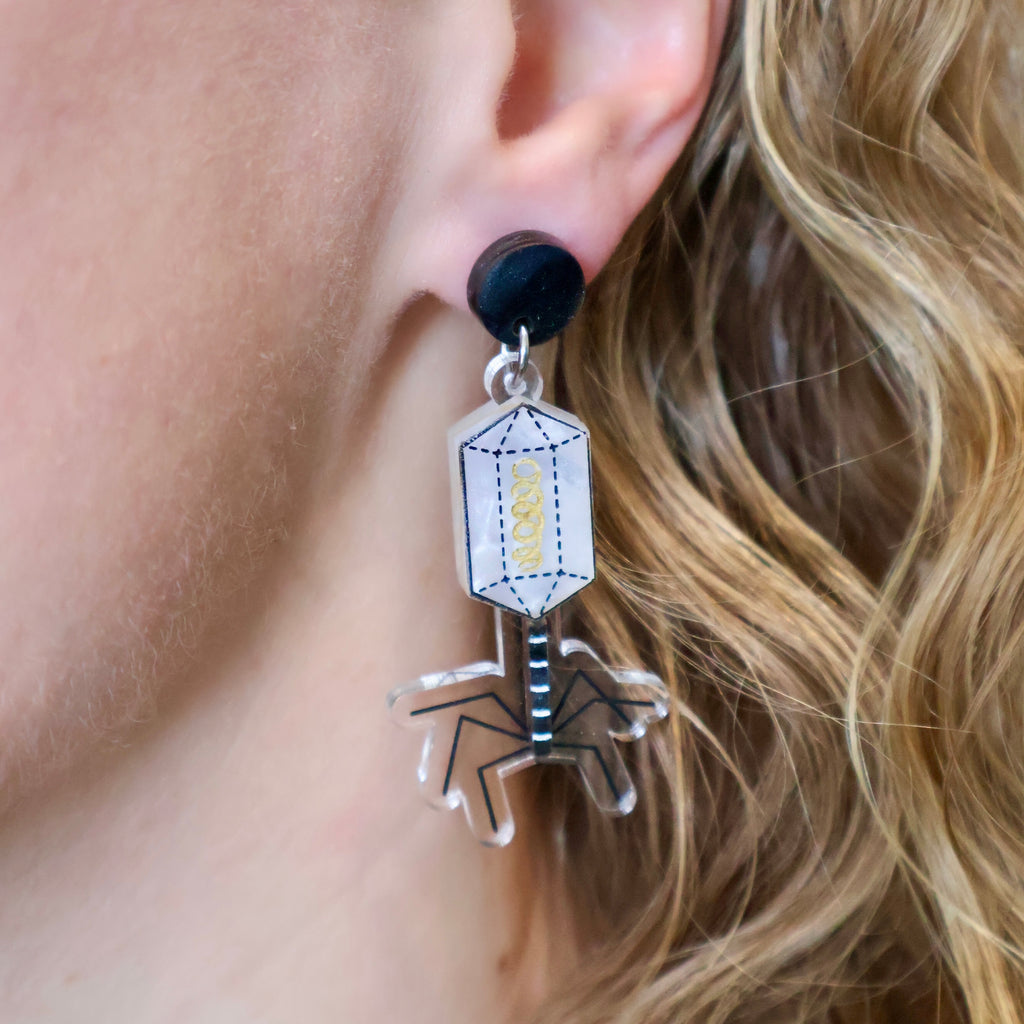 Asymmetrical Bacteria and Virus Earrings. Laser cut from acrylic. The virus earring is being modelled. 