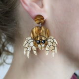 Laser cut acrylic jumping spider earrings, being modelled.