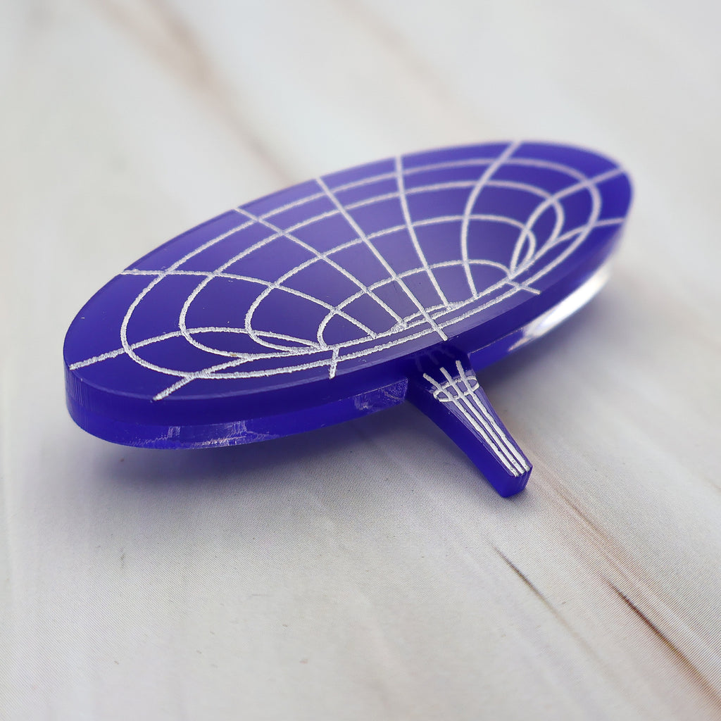 Angled view of dark blue wormhole brooch