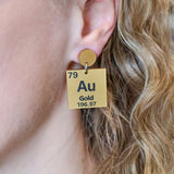 Gold periodic table earrings being modelled. 