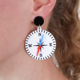 Earring with compass design worn by a person