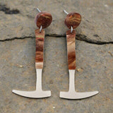A pair of earrings designed to resemble fossil hammers with a silver pearlescent and brown swirly acrylic finish, attached to surgical steel posts with comfort clutch earring nuts. Laser cut acrylic.