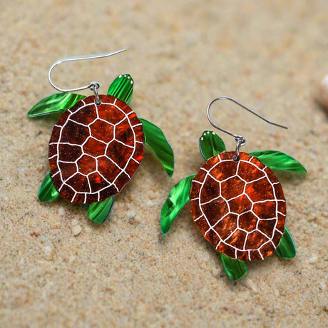Turtle-shaped acrylic earrings with brown shell design on a light blue background