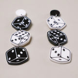 Pair of dice-shaped earrings on a light gray background