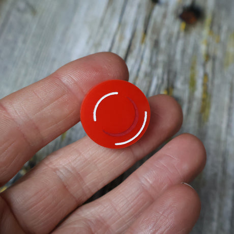 closeup of acrylic red blood cell pin in hand