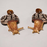 closeup view of a pair of acrylic snail earrings showing fine details