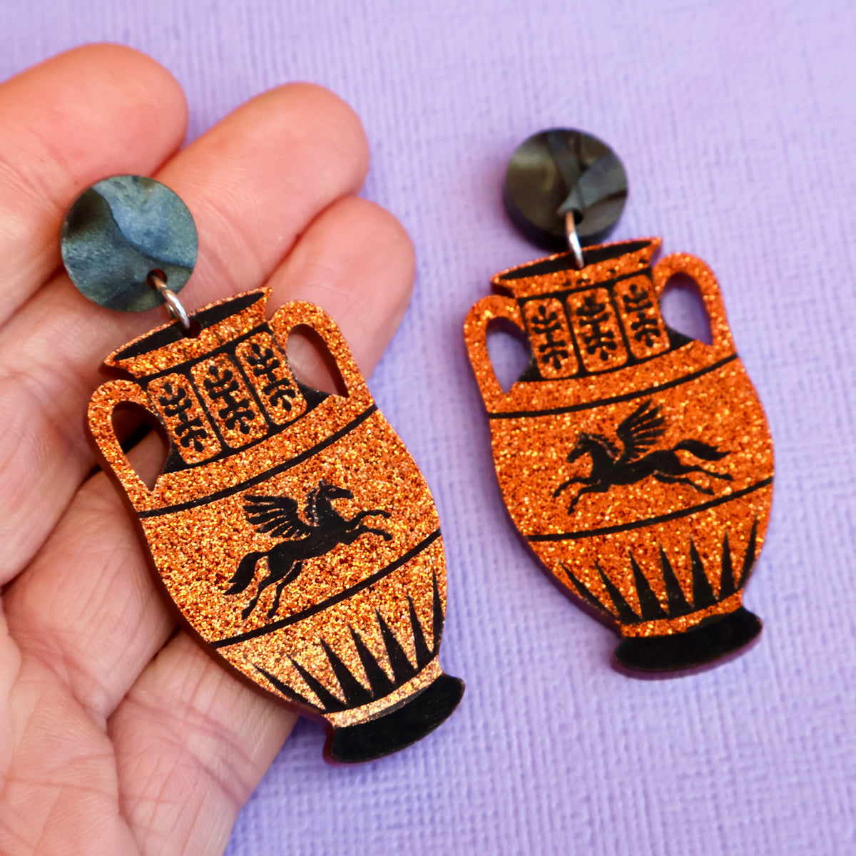 Amphora jar earrings in hand