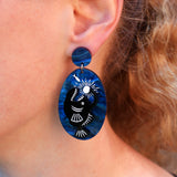 Anglerfish acrylic earrings being modelled on a ladies ear.
