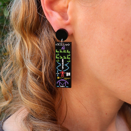 Acrylic earrings depicting the arecibo message being modelled. 
