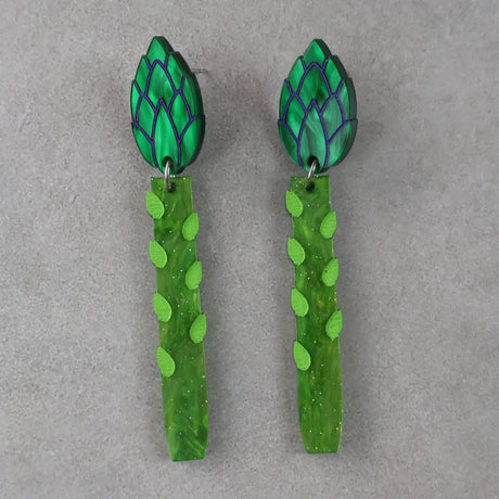 Green asparagus acrylic earrings with leaf-shaped toppers earrings on a grey background