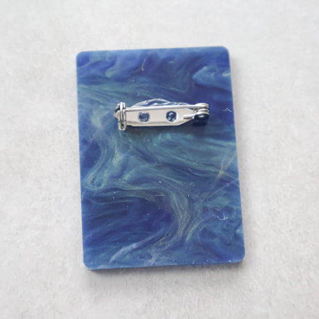 Back view of the binary code brooch showing stainless steel brooch pin and rolling clasp