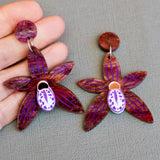 Black orchid earrings in hand