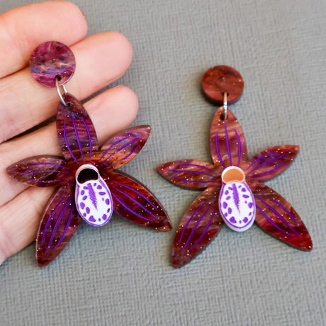 Black orchid earrings in hand