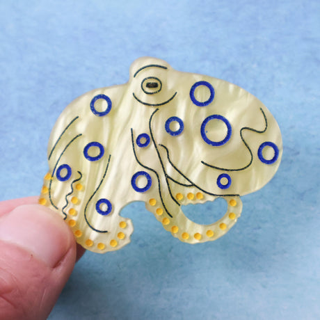 Blue ringed octopus acrylic brooch being held in a ahand